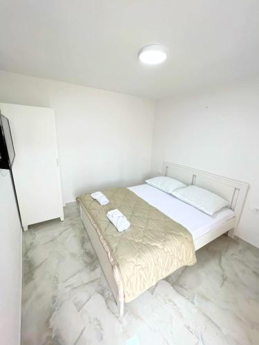 a bedroom with a bed with two towels on it at Apartman Laura in Mlini