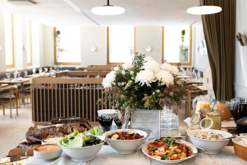 a table with bowls of food and flowers on it at RUNO Hotel Porvoo in Porvoo