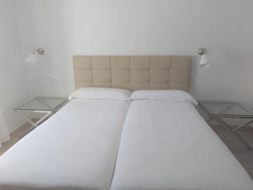 a large bed in a room with white walls at Hotel Cantabrico in Liérganes