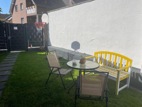 a patio with a table and chairs and a bench at Gemütliche 1-Zimmer Wohnung mit eigenem Eingang in Wesseling