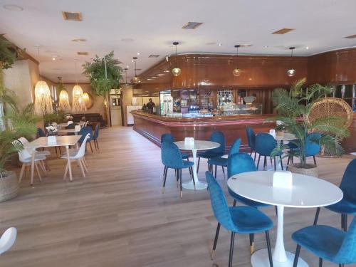 un restaurante con mesas y sillas y un bar en Hotel Cantabrico, en Liérganes