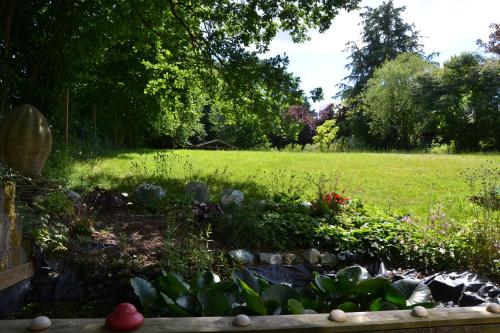 a garden with a field in the background at La Chapelle de verre, un lieu unique au monde in Ronquières
