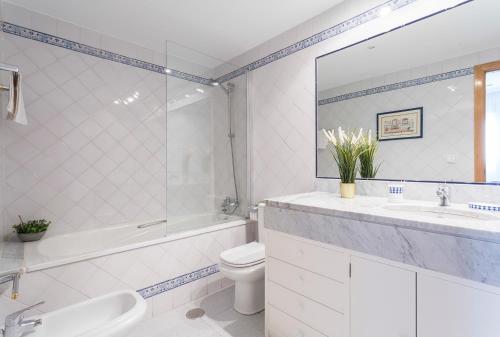 ein Badezimmer mit einem Waschbecken, einem WC und einer Badewanne in der Unterkunft Avenida Playa 3 Rooms 2 baños in Cádiz