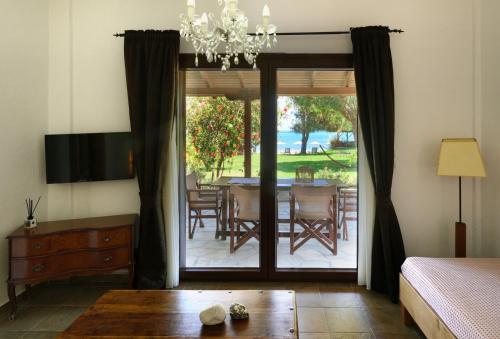 a bedroom with a sliding glass door with a table and chairs at 4Elies apartments in Vourvourou
