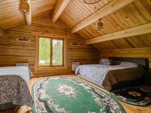 a bedroom with two beds in a log cabin at Vila Juodenėnai in Žaugėdai