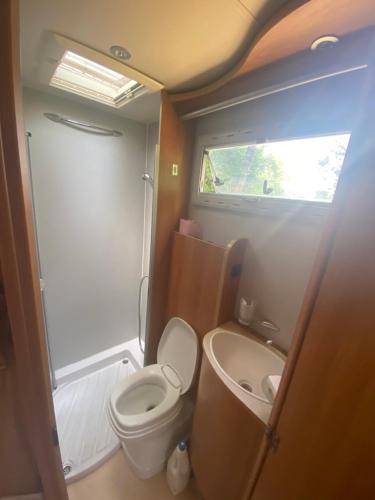 a small bathroom with a toilet and a sink at Camping car Canal du Midi in Montesquieu-Lauragais