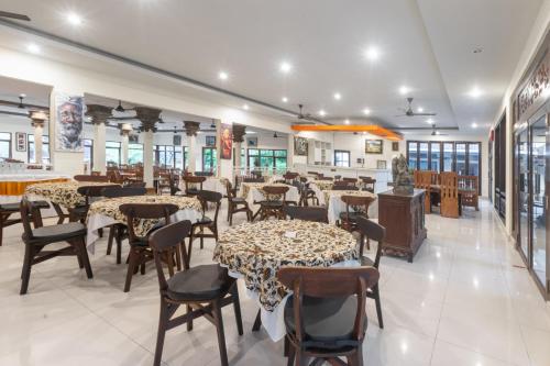 a restaurant with tables and chairs in a room at Dewi Sinta Hotel and Restaurant in Tanah Lot