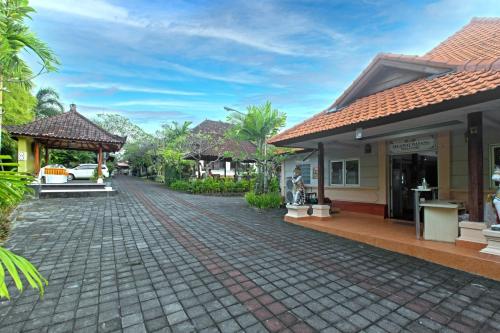 a cobblestone street in front of a house at Dewi Sinta Hotel and Restaurant in Tanah Lot