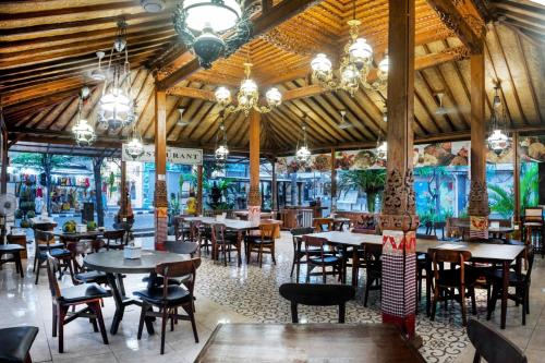 a dining room with tables and chairs in a restaurant at Dewi Sinta Hotel and Restaurant in Tanah Lot