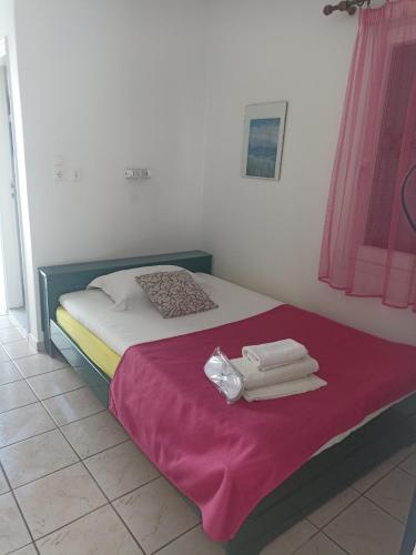 a bedroom with a bed with towels on it at Pagali Hotel in Órmos Aiyialís