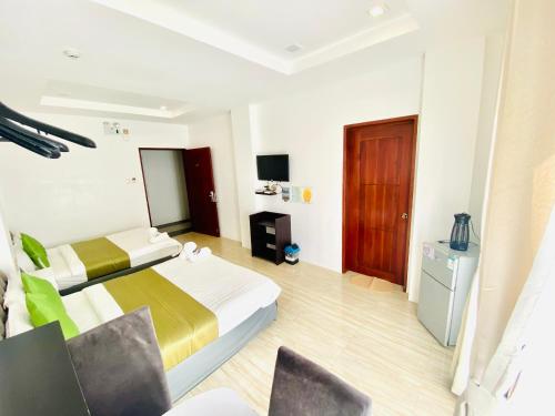 a hotel room with two beds and a television at Mirage Suites de Boracay in Boracay