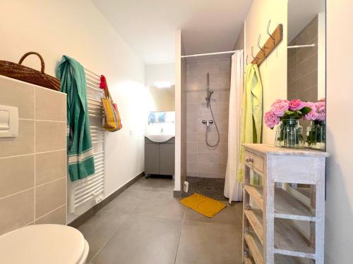 a bathroom with a shower and a toilet and a sink at Le Clos des Vieux Moulins in La Flotte