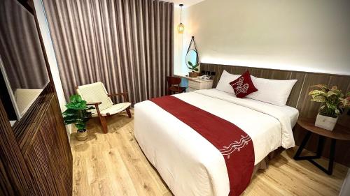 a hotel room with a large bed and a chair at 海的墾丁旅店 Ocean KT Inn in Kenting