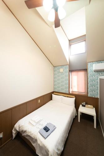 a bedroom with a bed and a ceiling fan at ETAVIA Yufuin Kinrinko in Yufuin