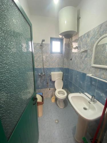 a bathroom with a toilet and a sink and a shower at DRINI in Velipojë