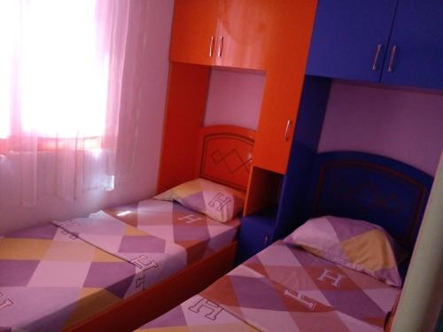 two twin beds in a room with a window at DRINI in Velipojë