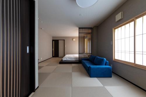 a room with a blue couch and a bed at Iwasu-so in Nakatsugawa
