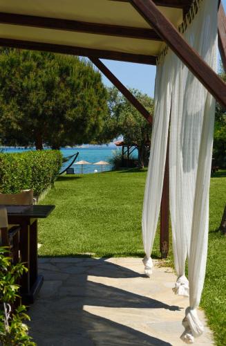 a white curtain on a patio with a view of the ocean at 4Elies apartments in Vourvourou