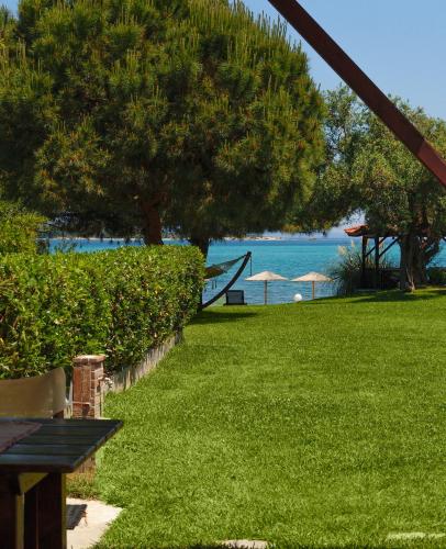 a park with a bench and a view of the water at 4Elies apartments in Vourvourou
