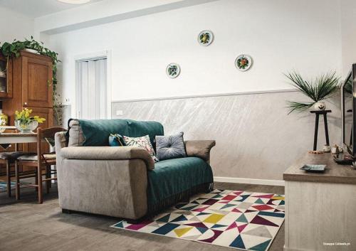 a living room with a green couch and a table at Casa Nonna Fortunata in Canicattini Bagni