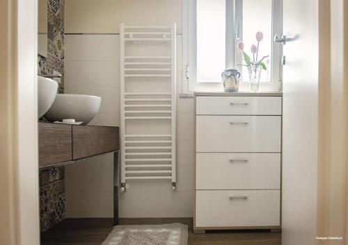a white bathroom with a sink and a window at Casa Nonna Fortunata in Canicattini Bagni