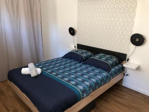 a bedroom with a bed with a teddy bear on it at Loft du sud ouest av garage in Laplume