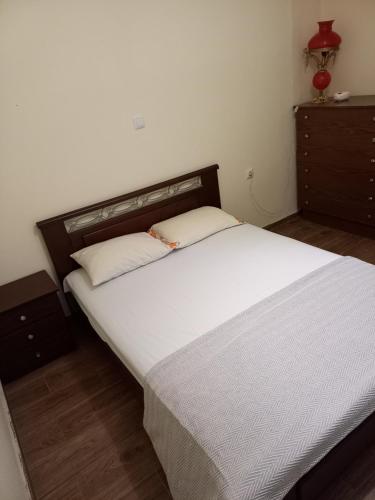 a bedroom with a large white bed with a wooden headboard at Stellas apartment in Évdhilos