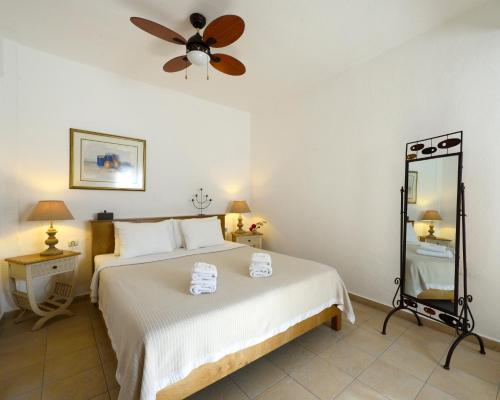 a bedroom with a bed and a ceiling fan at 4Elies apartments in Vourvourou