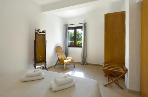 a bedroom with a bed and a chair and a window at 4Elies apartments in Vourvourou
