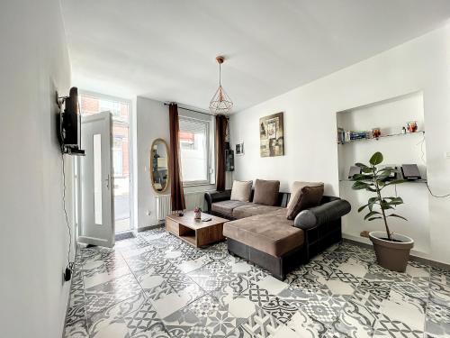 a living room with a couch and a table at Maison de ville jacuzzi wiffi à 4km aéroport Charleroi in Charleroi