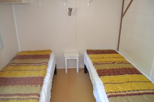a room with two beds and a small table at Camping maeva Escapades Le Casque Roi in Salavas