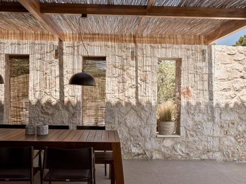 jadalnia ze stołem i kamienną ścianą w obiekcie Cielo villas - An Authentic Mediterranean Living w mieście Zakintos
