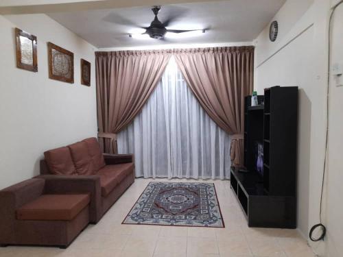 a living room with a couch and a television at Dhuha Homestay @ Seri Alam Masai , Johor in Masai