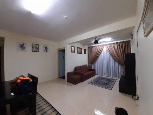 a living room with a couch and a chair at Dhuha Homestay @ Seri Alam Masai , Johor in Masai