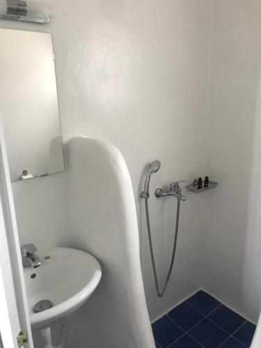 biała łazienka z umywalką i prysznicem w obiekcie Petrosfamily4 w mieście Agios Ioannis