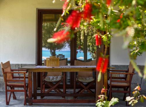a wooden table and chairs with a view of the ocean at 4Elies apartments in Vourvourou
