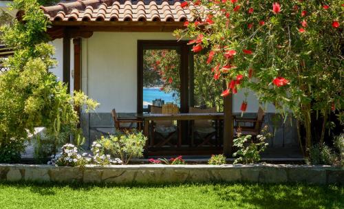 a house with a table and flowers in the yard at 4Elies apartments in Vourvourou