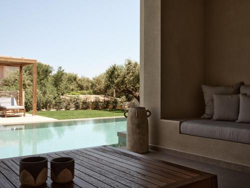a living room with a swimming pool and a couch at Cielo villas - An Authentic Mediterranean Living in Zakynthos Town