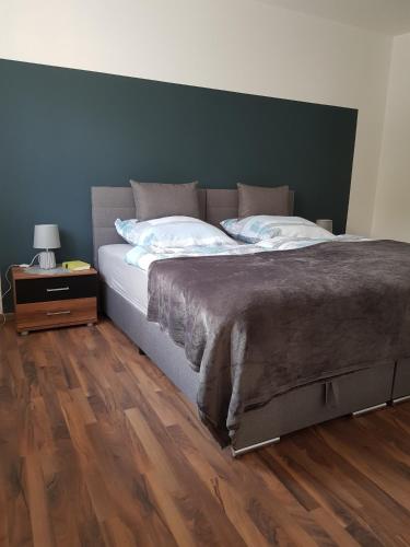 sypialnia z dużym łóżkiem i drewnianą podłogą w obiekcie Wiesental 