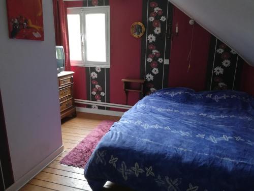 a bedroom with a blue bed and a window at PROPRIETE BORDEE D'ETANGS, PROPICE A LA DETENTE in Florenville