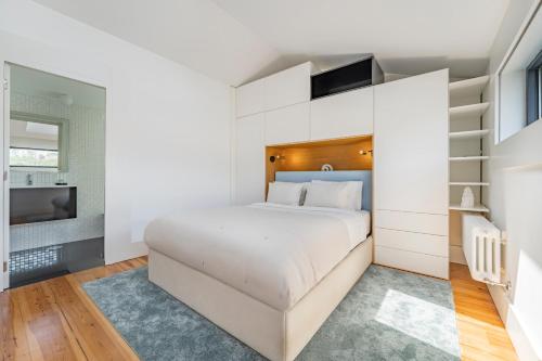 biała sypialnia z łóżkiem i schodami w obiekcie Art Douro Historic Distillery w mieście Vila Nova de Gaia