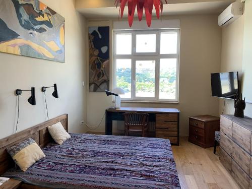 a bedroom with a bed and a desk and a window at Riverside Gem in the city center in Budapest