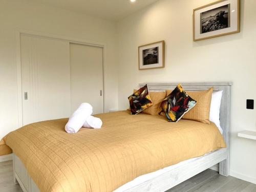 a bedroom with a large bed with pillows on it at Ohope Villas with Spa,Sauna,Pool, Adults Only in Ohope Beach