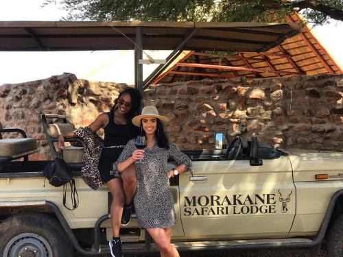 Duas mulheres sentadas na traseira de um camião. em Morakane Safari Lodge em Vryburg