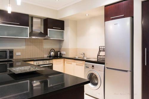 a kitchen with a refrigerator and a washer and dryer at Icon Luxury Apartments - Central Cape Town in Cape Town