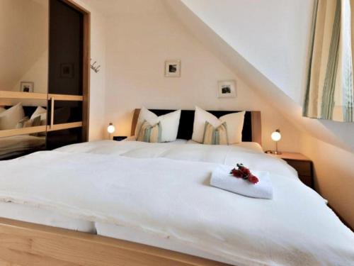 ein Schlafzimmer mit einem großen weißen Bett mit Blumen darauf in der Unterkunft Ferienwohnung 39 Mauersegler - Urlaub in der Natur in Timmendorfer Strand