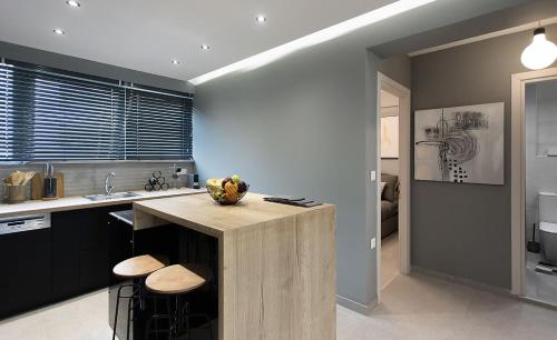 - une cuisine avec un îlot au milieu d'une pièce dans l'établissement GreyHouse Corfu διαμέρισμα στο κέντρο τις Κέρκυρας, à Ágios Rókkos