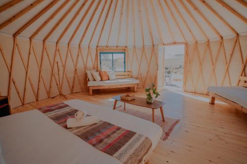 a yurt with a couch and a table in it at Alpaca Farm - חוות האלפקות in Mitzpe Ramon