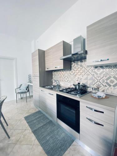 a kitchen with white cabinets and a stove top oven at Casa Vacanze , Scoglitti in Scoglitti