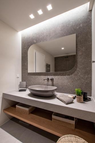 a bathroom with a sink and a large mirror at LazySun in Sounio